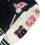 Close-up view of the white leather sleeve and chest embroidery details on a SP5DER Division 5 Varsity Jacket design.