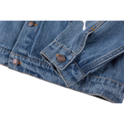 Close-up view of the sleeve and button detail on the premium blue denim SP5DER Worldwide streetwear jacket.