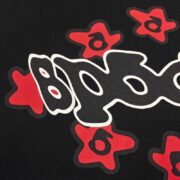 Close up of the Sp5der Warped Tee in black featuring a distorted graphic design with iconic red star elements.