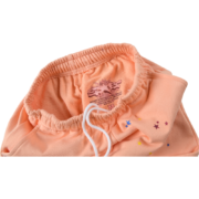 Detailed interior label and tag view of the premium Sp5der Bellini sweatpants in peach colorway