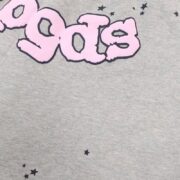 Close up of the Sp5der OG Web Logo sweat short fabric with pink puffy lettering and black star graphic details.