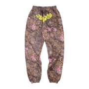 Front view of Sp5der Real Tree OG Web sweatpants in brown camouflage with yellow lettering and floral patterns.
