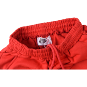 Detailed view of the elasticated waistband and Sp5der brand label on the vibrant red Atlanta open leg sweatpants.