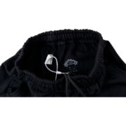 Interior label detail of black Sp5der Souvenir SP5 sweatpants with elasticated waistband and drawstring cord.