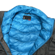 Detailed view of the bright blue interior lining and branded label inside a Sp5der men’s light down puffer jacket