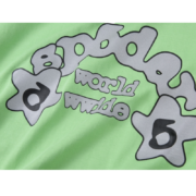Close up view of the SP5DER Worldwide graphic printed on a vibrant slime green cotton t-shirt for streetwear style.