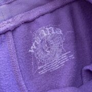 Close-up view of the inner label and branding details on the purple Sp5der Worldwide Wunna streetwear shorts.