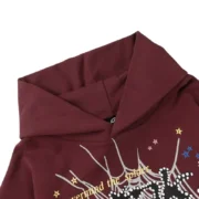 Close-up view of the hood detail on the Sp5der P*nk Hoodie in a bold maroon colorway with signature spider web graphics.