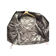 A close-up view of the high-quality quilted interior of the Sp5der Worldwide Jacket on a wooden hanger.