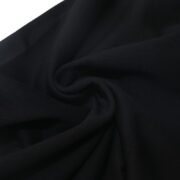 Close-up view of the black fabric texture used for the Sp5der OG Tree Camo sweatpants, showcasing quality material.