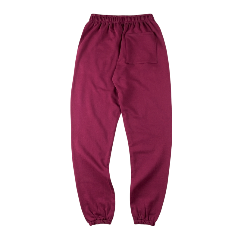 Back view of SP5DER Nocturnal Highway cotton track pants in a maroon colorway with a relaxed fit and pocket design.