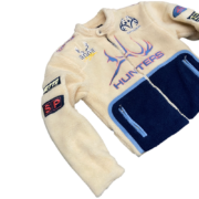 Sp5der Worldwide Hunters Sherpa Moto Jacket featuring branded patches and a cozy cream and navy blue fleece design.