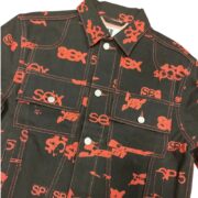 Front view of the Sp5der 5ex AOP denim trucker jacket featuring an all-over red graphic print on black fabric.