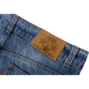 Sp5der Vintage Web Jean denim waistband featuring a tan leather logo patch with star graphic detailing and branding.