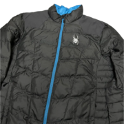 Front view of the black Sp5der men’s light down puffer jacket featuring a blue zipper and the iconic spider logo.