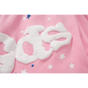 Close-up of premium Sp5der Atlanta pink sweatpants featuring the signature white distressed branding and star pattern.