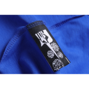 Close-up view of the branding tag detail on a premium royal blue SP5DER Young Thug T-shirt for streetwear fans.