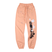 Front view of the Sp5der Bellini sweatpants in a vibrant peach hue featuring a unique graphic logo and star detailing.