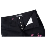 Close up view of the Sp5der 5Star Vintage 501 Denim in black with pink star details and button fly closure.