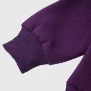 Close up view of the ribbed sleeve cuff on the vibrant purple Sp5der Web Hoodie made from premium heavyweight fabric.