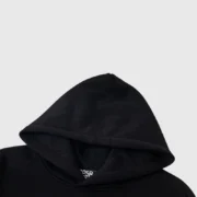 A close-up view of the black hood on the Sp5der Worldwide Web Hoodie with the brand logo visible on the inner label.