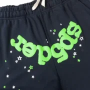 A close-up detail of the Sp5der Wait Web Sweatpant in Slate Grey featuring signature neon green branding and star design.