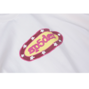 White cotton Sp5der streetwear t-shirt featuring a distinctive yellow and pink graphic logo with star accents