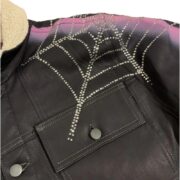 Sp5der trucker jacket featuring a signature rhinestone web detail and a warm sherpa lining for a bold streetwear look.