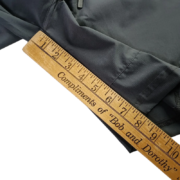 Close-up view of a ruler measuring the leg opening of black Sp5der Active TECH performance shorts for accurate sizing.