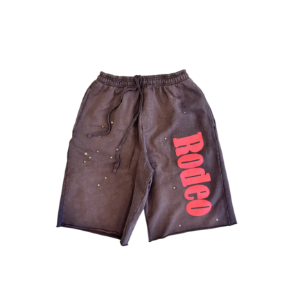 Front view of the Sp5der x Cactus Jack Rodeo shorts featuring pink lettering and star accents on dark fabric.