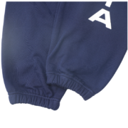 Close-up view of the leg detail on the Sp5der Arach NY Phobia blue sweatpants featuring white graphic branding text.