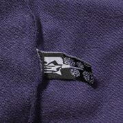 Close-up view of the branded Sp5der label stitched onto the premium navy-blue fabric of the Beluga sweatpants.