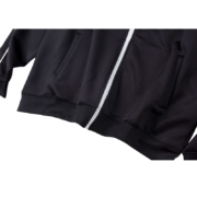 Close-up front view of the black SP5DER G550 performance jacket featuring a white center zipper and sleek finish.