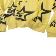 A close up of the yellow Sp5der 5Star hoodie showing the black star print and premium fabric details.