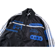 Stylish black Sp5der satin bomber jacket featuring blue embroidered branding and athletic detailing for streetwear.