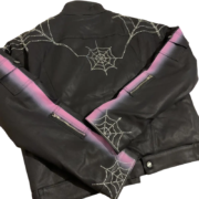Black Sp5der trucker jacket featuring a signature rhinestone spiderweb design and purple gradient sleeve accents.