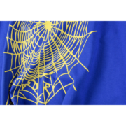 Close-up view of the iconic yellow spider web graphic printed on a vibrant royal blue Sp5der OG V2 streetwear t-shirt.