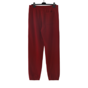 A pair of red Sp5der OG Tree Camo sweatpants hanging on a display hanger for a premium urban street style fashion look.