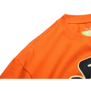 Close-up of the orange Sp5der Worldwide Star Beluga T-Shirt showing premium fabric and graphic design details.