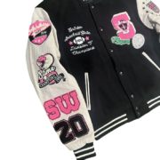 Detailed view of the SP5DER Division 5 varsity jacket chest and sleeve showing embroidered patches and premium design.