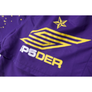 Close-up of the Sp5der SP5 Pro Short in purple featuring the iconic yellow logo graphic and five-star print pattern.