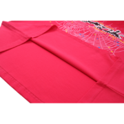 Close-up view of the hem detail on a vibrant pink Sp5der T-shirt featuring an intricate white web print design.
