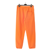 Back view of orange Sp5der Websuit sweatpants with a loose fit, elasticated waistband, and rear pocket design.