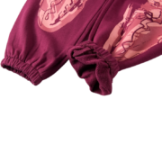Close-up view of the SP5DER Nocturnal Highway cotton track pants featuring unique graphic designs and ribbed cuffs.