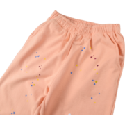 Sp5der Bellini sweatpants in a vibrant peach colorway with scattered star graphic design details, front view.