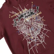 Close-up of the maroon Sp5der P*nk hoodie showing the front graphic with white spider web and star details.