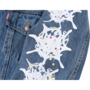 Close-up view of the SP5DER Worldwide denim jacket sleeve showcasing the signature white graphic and colorful star detail.