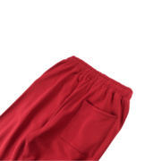 Close-up view of the back pocket detail on the premium maroon SP5DER logo sweatpants featuring soft fleece fabric.