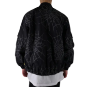 Back view of the Sp5der Number Nine jacket featuring a bold black streetwear graphic design with spiderweb patterns.