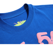 Close-up view of the collar and neck detail on the vibrant blue Sp5der Worldwide Star graphic streetwear T-shirt.